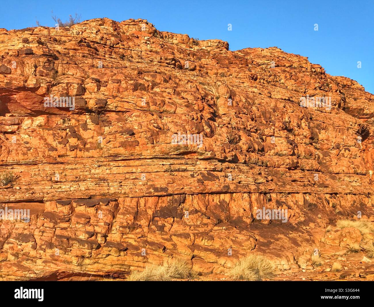 Early morning sunlight on a cliff face at Kings Canyon in Watarrka National Park, Northern Territory, Australia - Smartphone Captured Stock Image
