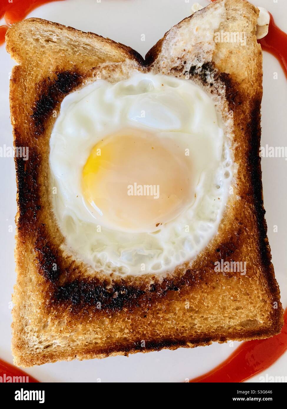 Fried egg cooked inside fried bread Stock Photo Alamy