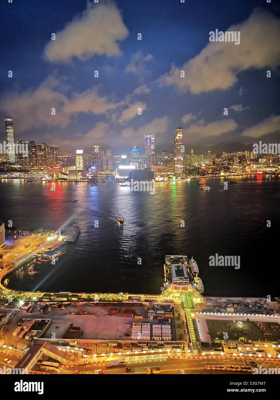 The Wan chai Star Ferry pier, Victoria Harbour and Kowloon at night. - Smartphone Captured Stock Image