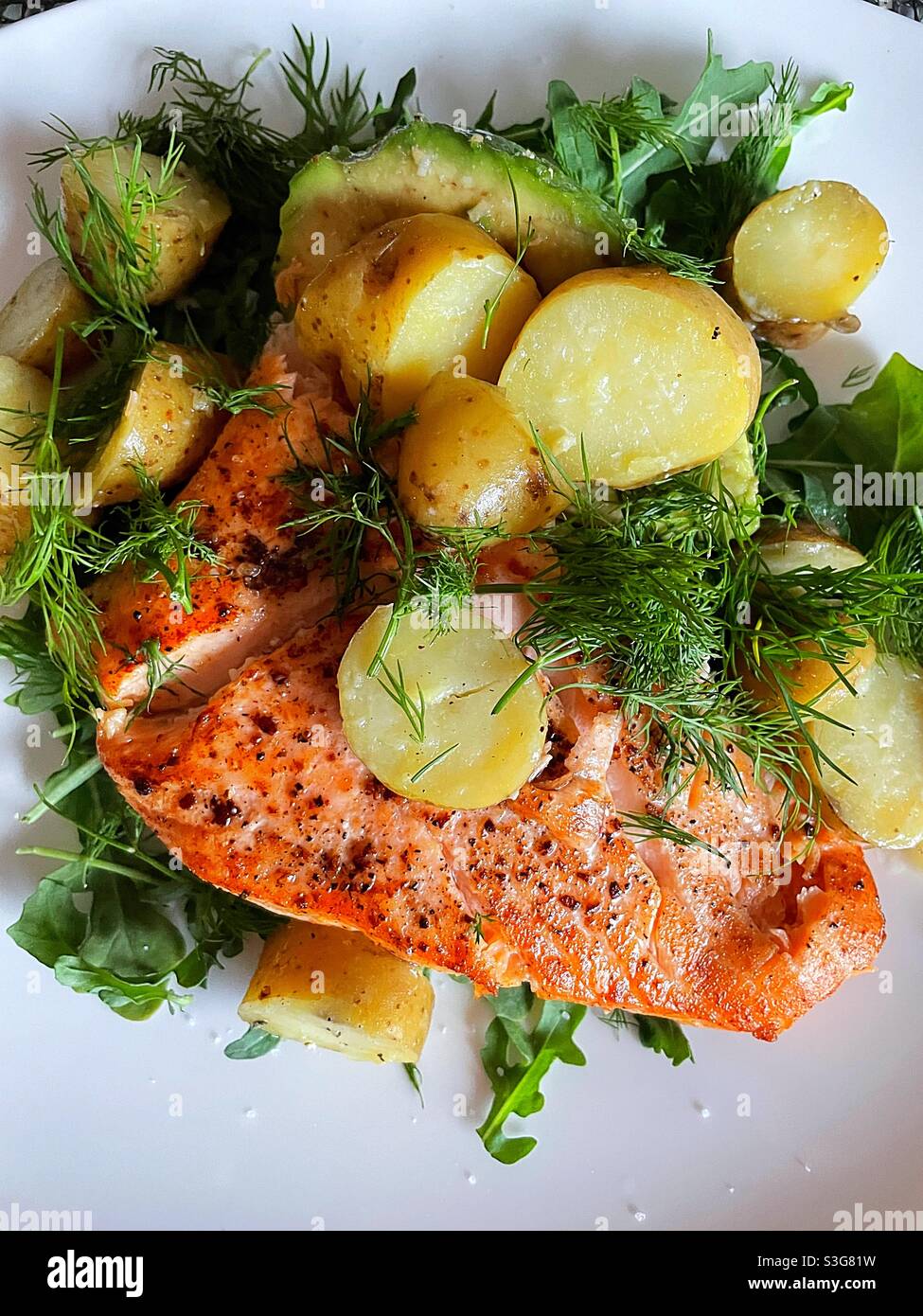 Flat lay of salmon and arugula with creamery new potatoes in a dill vinaigrette - Smartphone Captured Stock Image
