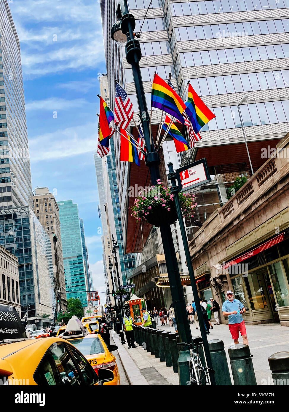 Gay pride rainbow flags in American flags on display in front of Grand Central terminal on E. 42nd St. in Midtown Manhattan, NYC, USA - Smartphone Captured Stock Image