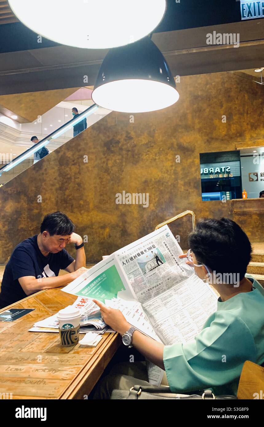 Reading the morning paper in Hong Kong. Stock Photo