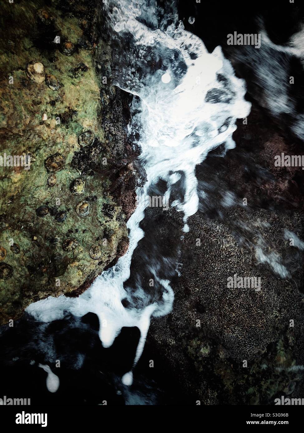 Motion blurred image of waves hitting the rocky shore - Smartphone Captured Stock Image