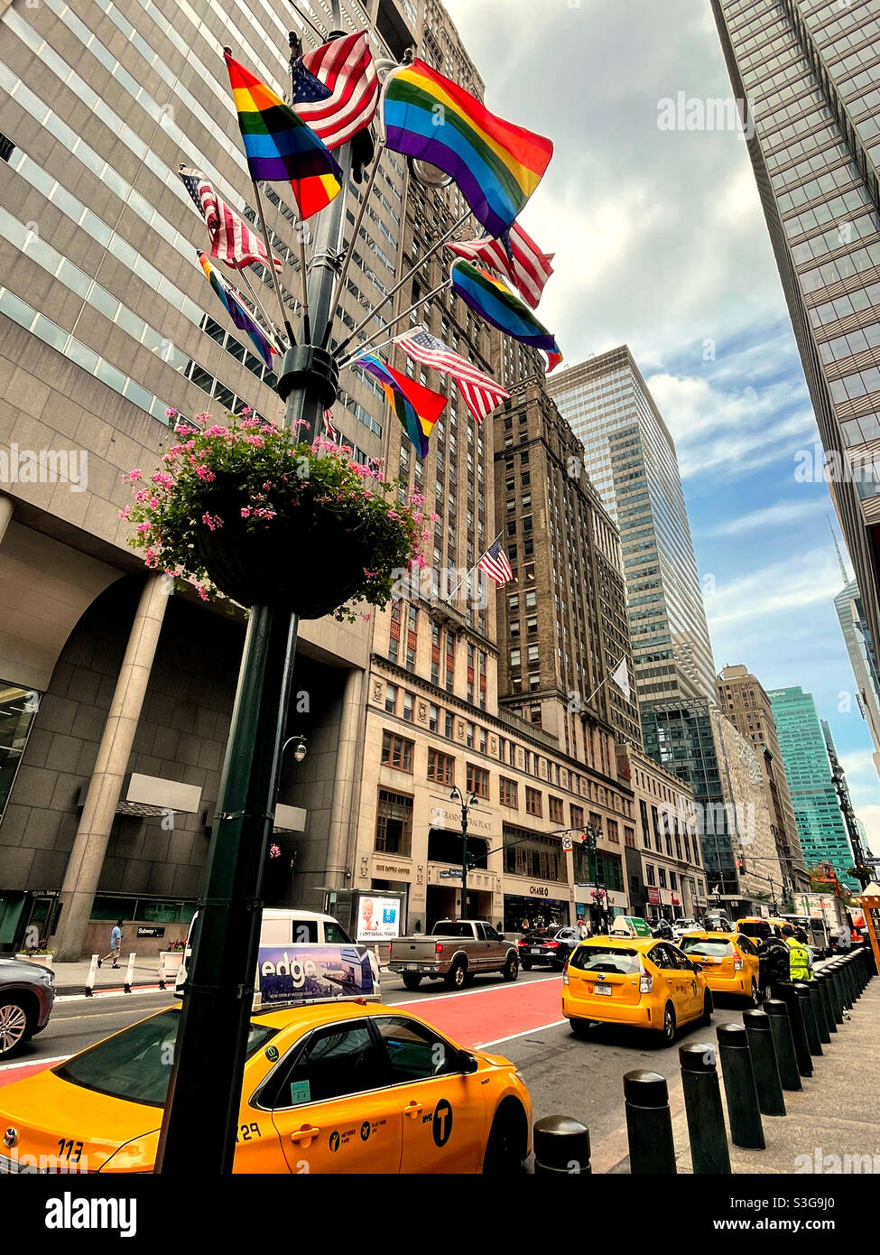 American and rainbow flags blowing in the wind at the taxi stand in front of Grand Central terminal on E. 42nd St., 2021, NYC, USA - Smartphone Captured Stock Image