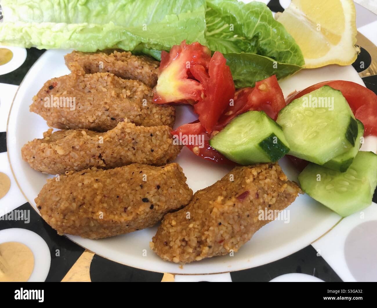 Turkish vegan dish cig kofte served with vegetables and lettuce Stock Photo