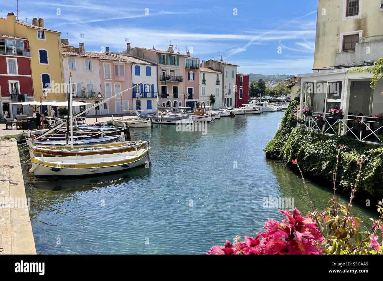 Canal with flowers, fishing boats and restaurants in Martigues, near Marseille, Bouches-du-Rhône, Provence-Alpes-Côte d'Azur, south of France - Smartphone Captured Stock Image