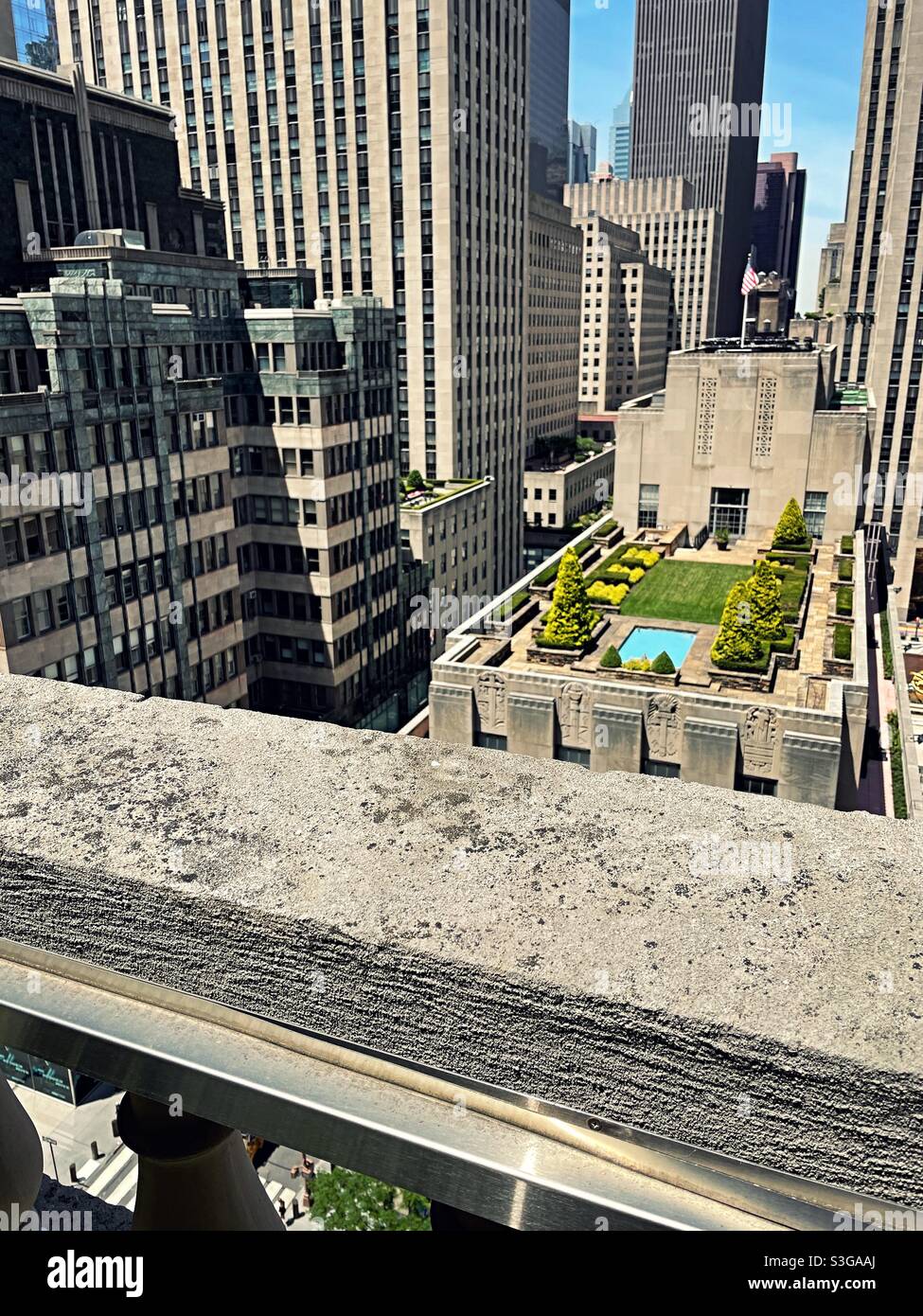 A formal English landscaped garden on top of a building at Rockefeller Center as seen from a balcony at Saks Fifth Avenue across 5th Ave., NYC, USA Stock Photo