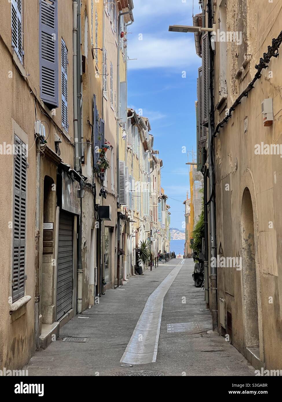 A narrow street leading to the waterfront and port, downtown La Ciotat, near Marseille, Bouches-du-Rhône, Provence-Alpes-Côte d'Azur, south of France - Smartphone Captured Stock Image
