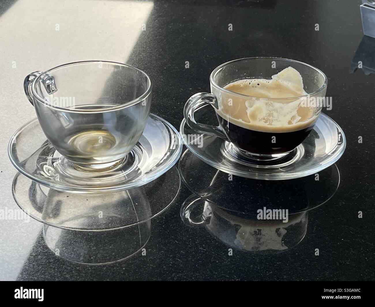 empty cup and half-full cup of freshly brewed coffee Stock Photo