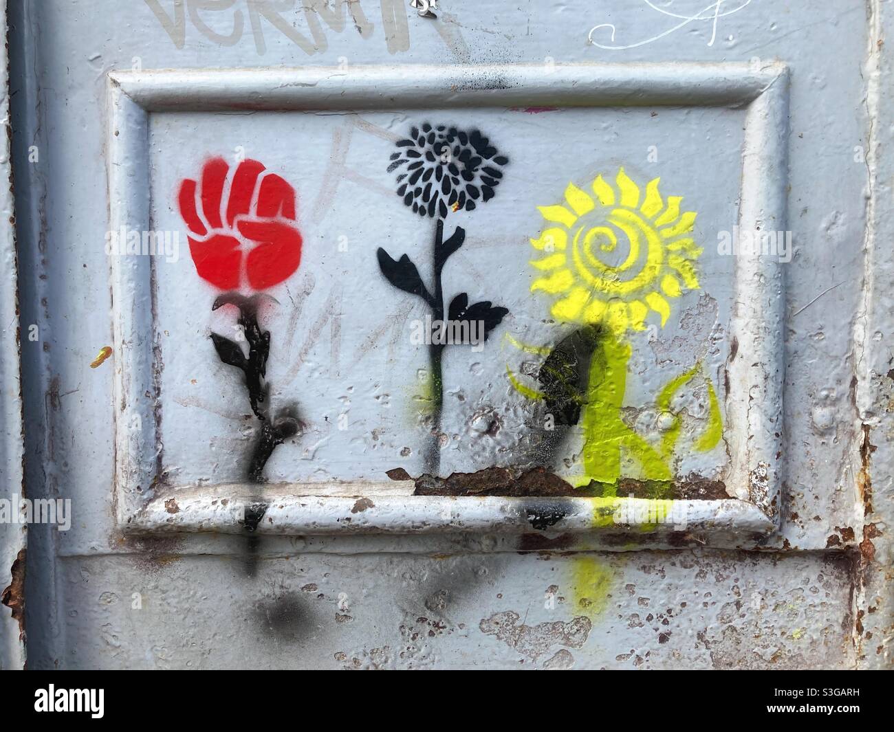 Stencil graffiti of flowers, one with a fist Stock Photo