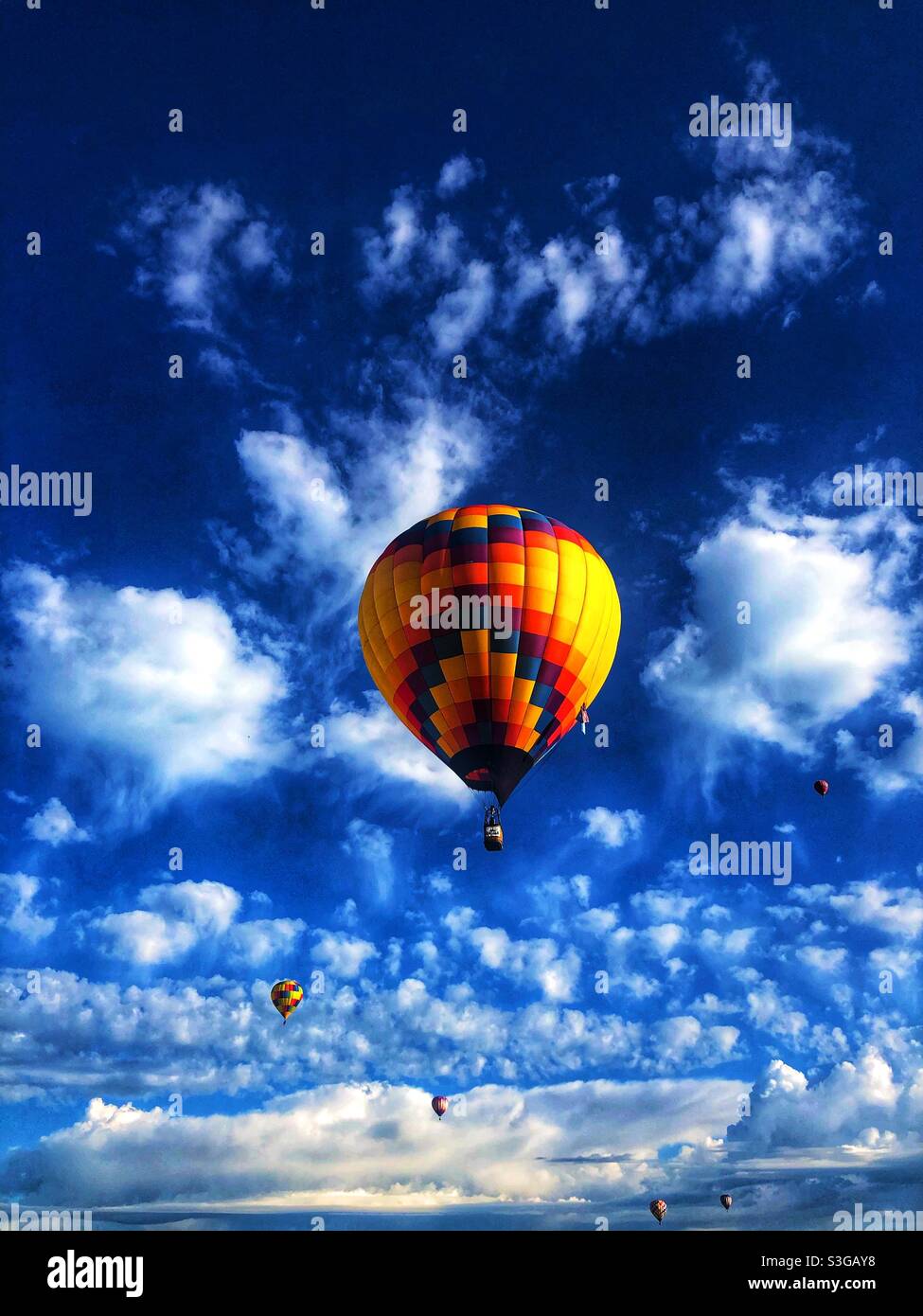 Hot air balloons against a brilliant blue sky with fluffy clouds Stock ...