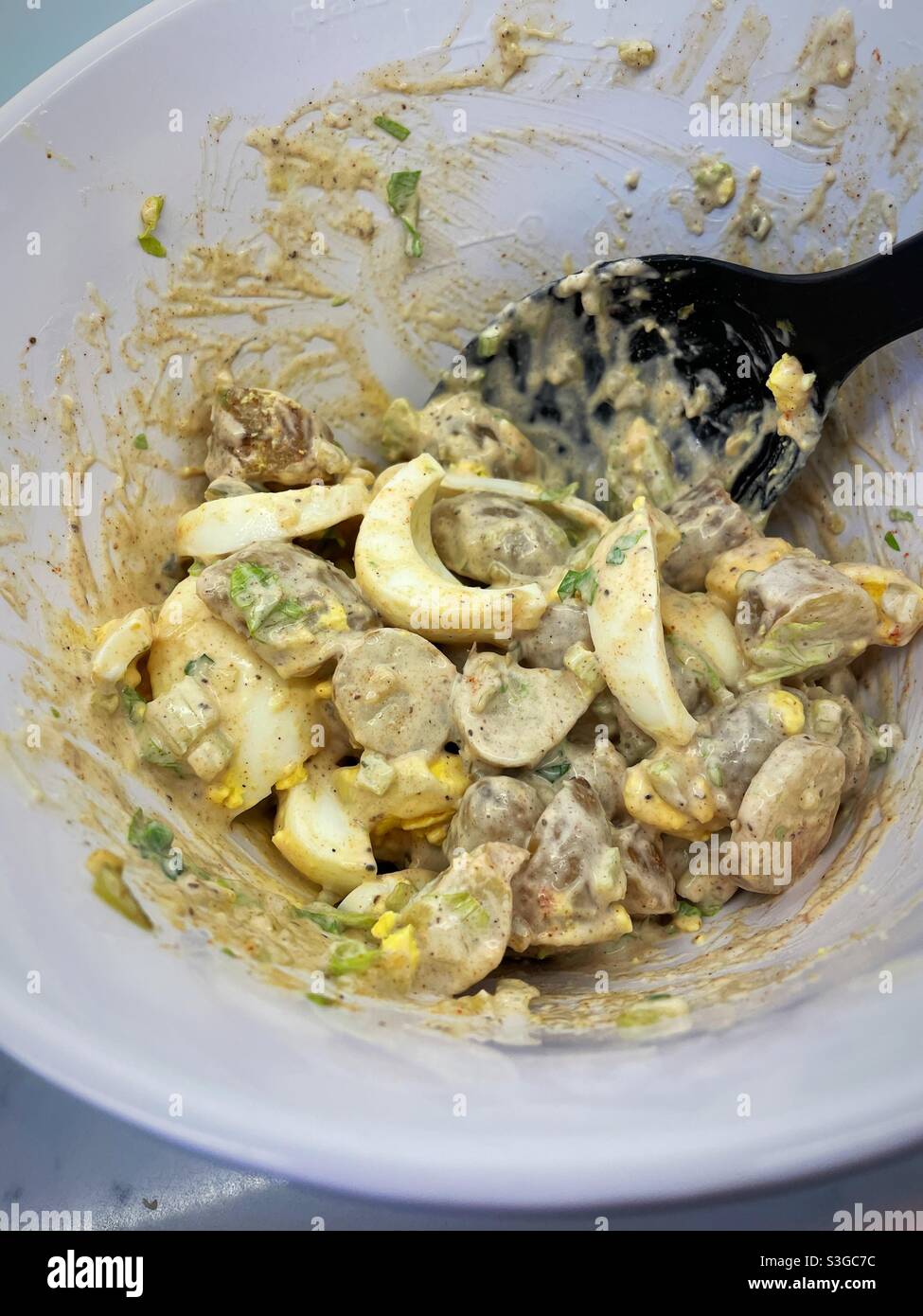 Large slices of hard-boiled eggs are added to a tasty potato salad - Smartphone Captured Stock Image