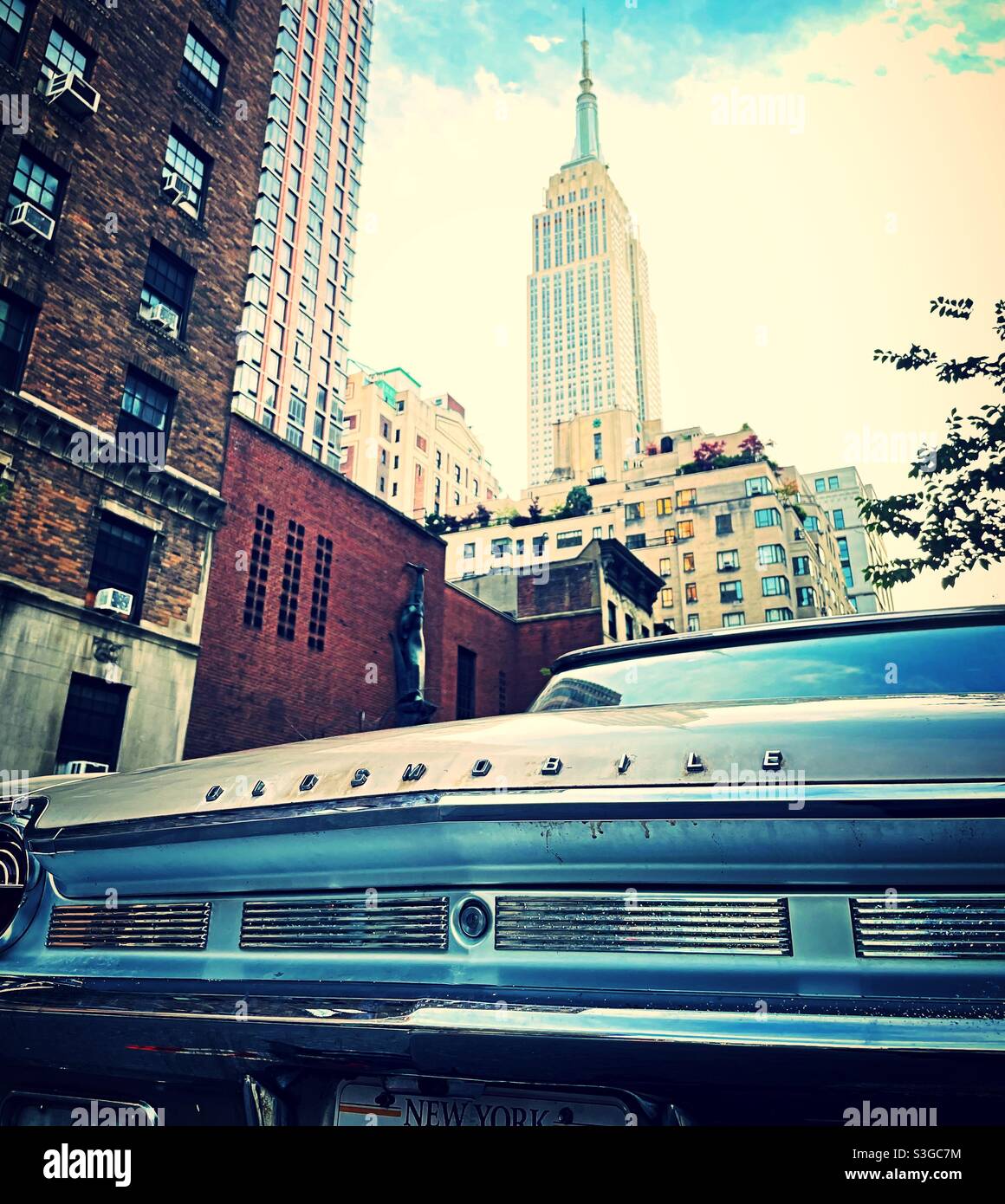 A vintage Oldsmobile automobile is parked in Murray Hill, and neighborhood near the empire state building, NYC, USA - Smartphone Captured Stock Image