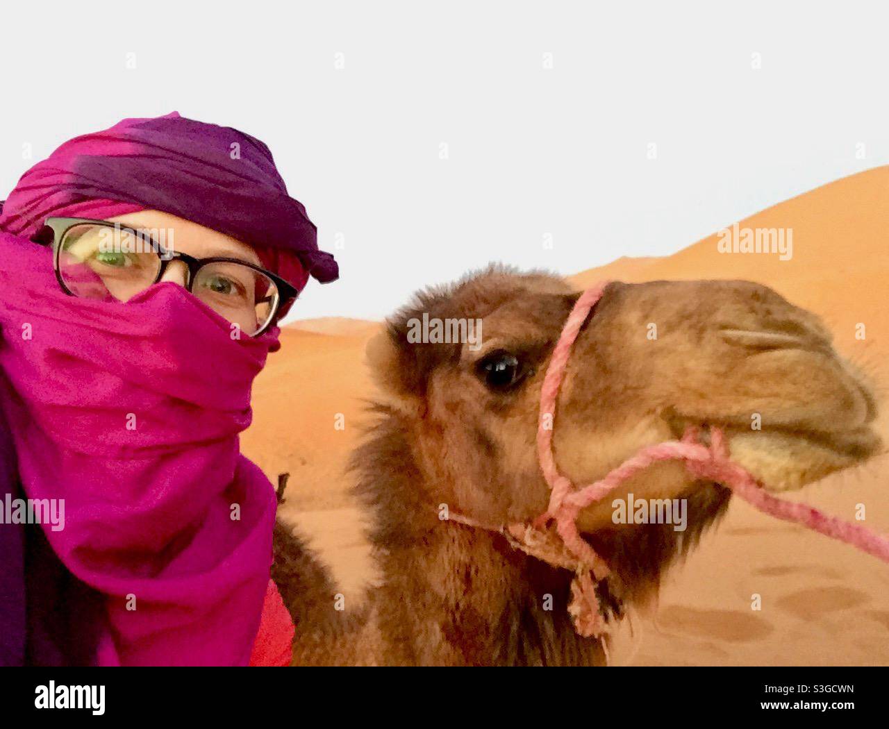 Woman posing with camel in Sahara desert, morocco Stock Photo