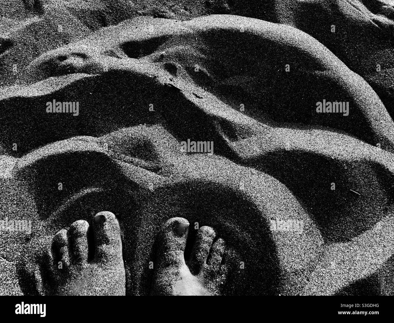 Monochrome image of Feet of a person on sandy beach - Smartphone Captured Stock Image