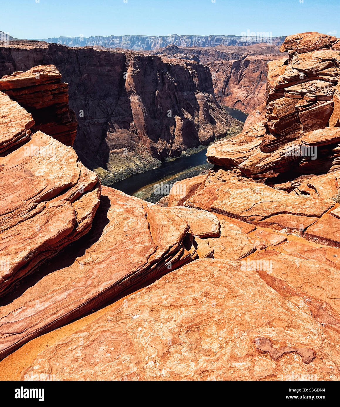 Colorado river snakes at the bottom of deep canyon in Horseshoe bend natural area in Arizona - Smartphone Captured Stock Image