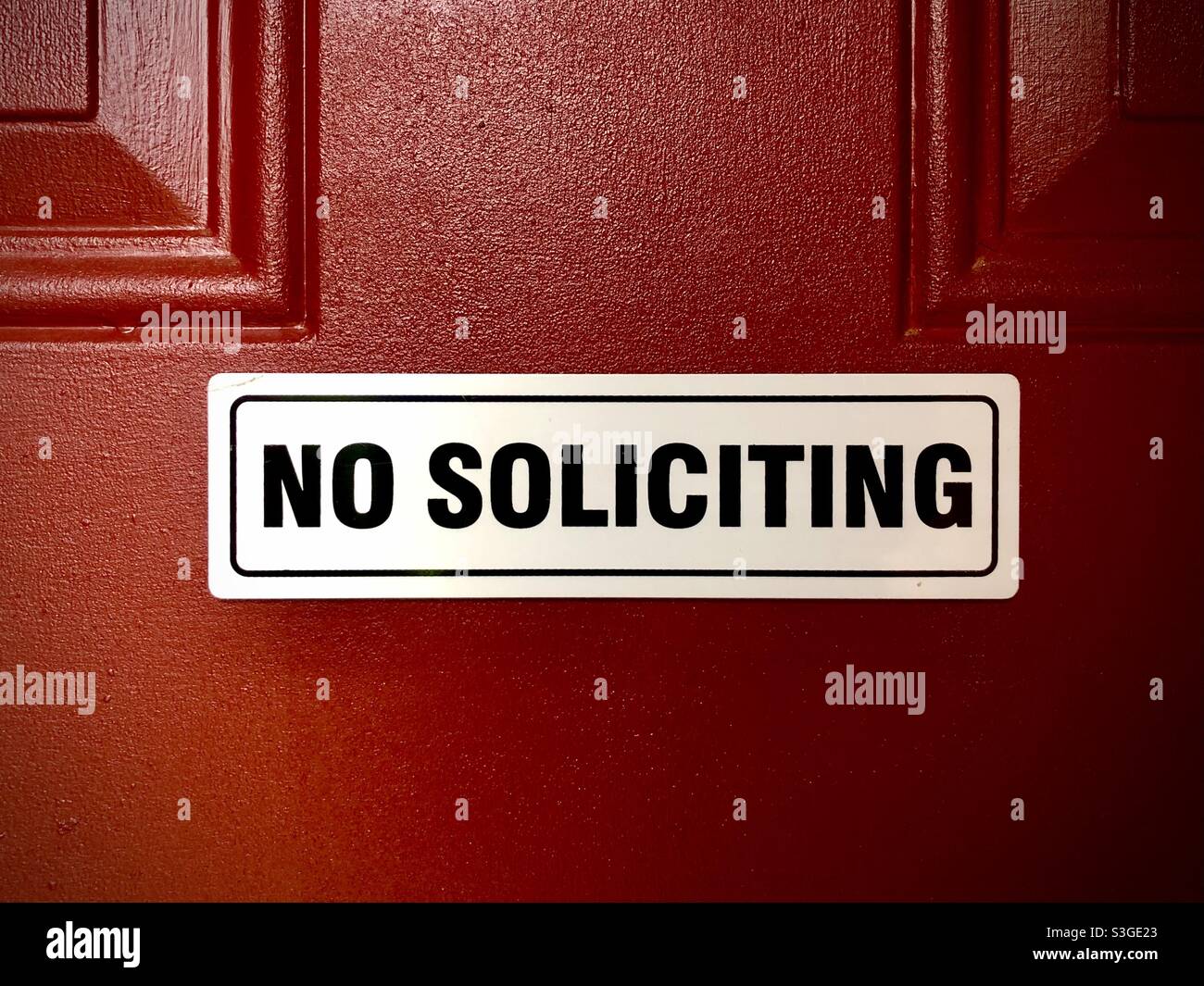 No soliciting sign on a red door Stock Photo