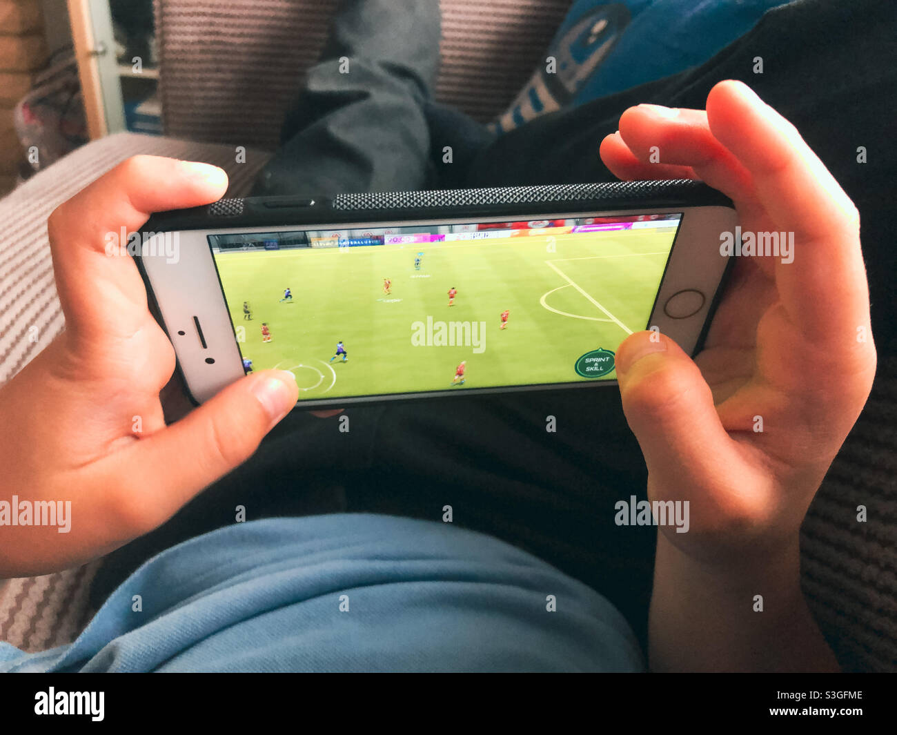 A child playing a football game on a mobile phone. - Smartphone Captured Stock Image