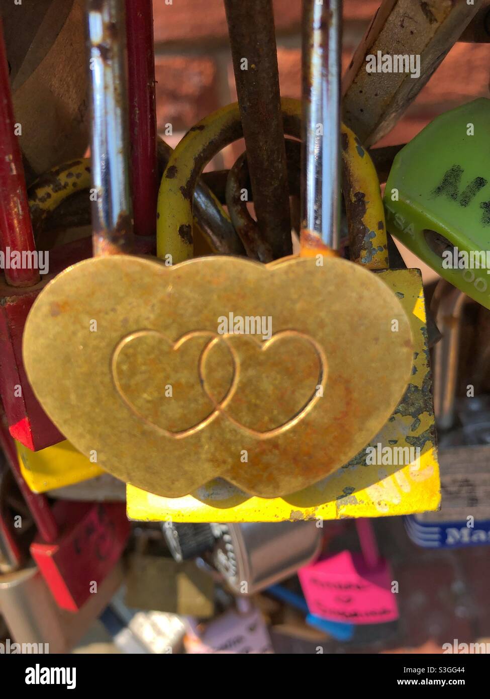 Two hearts intertwined etched on a brass love lock. Stock Photo