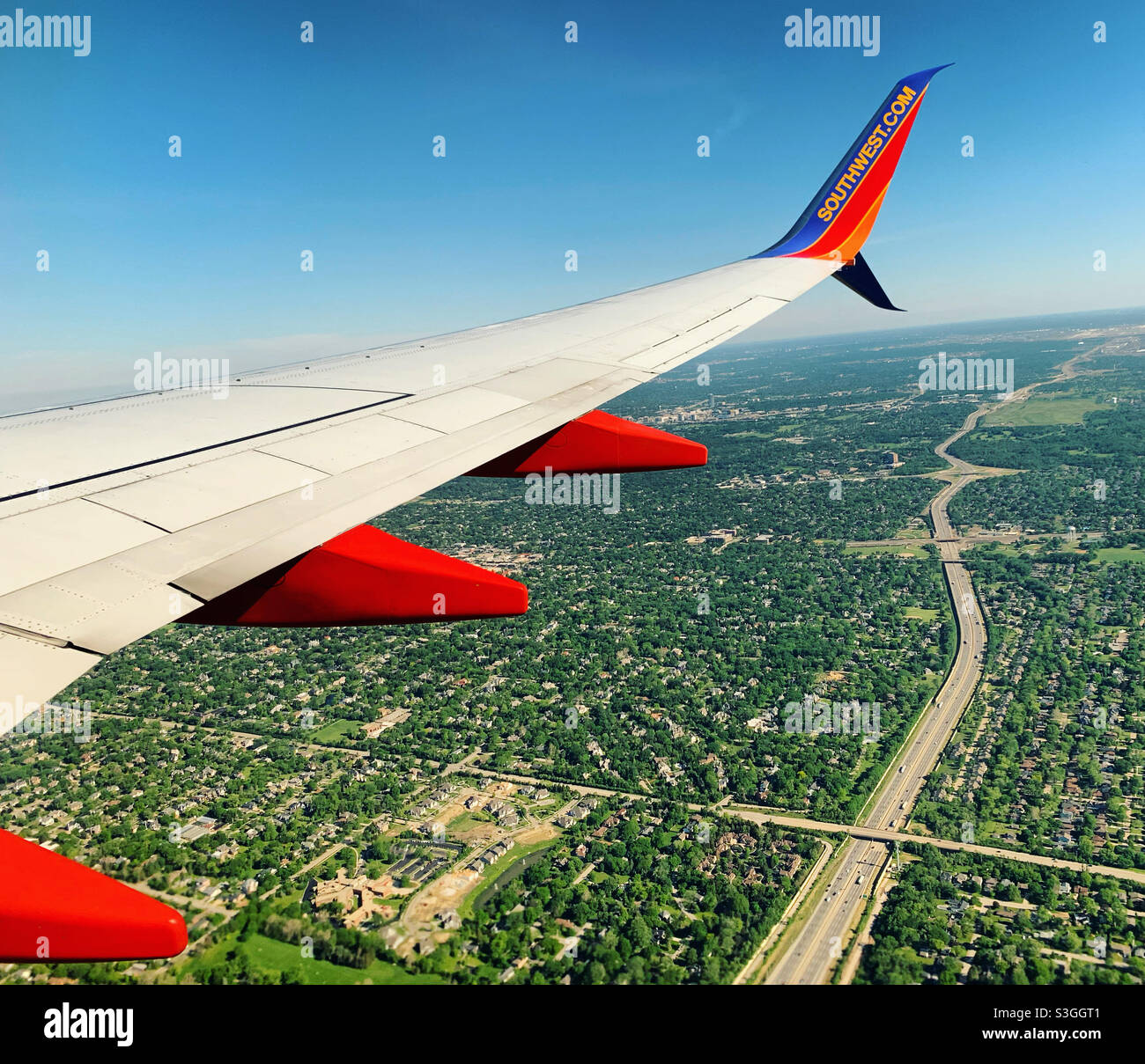 May, 2021, the wing of a Southwest Airlines plane flying over the town of Countryside, near Chicago Midway International Airport, Illinois, United States - Smartphone Captured Stock Image