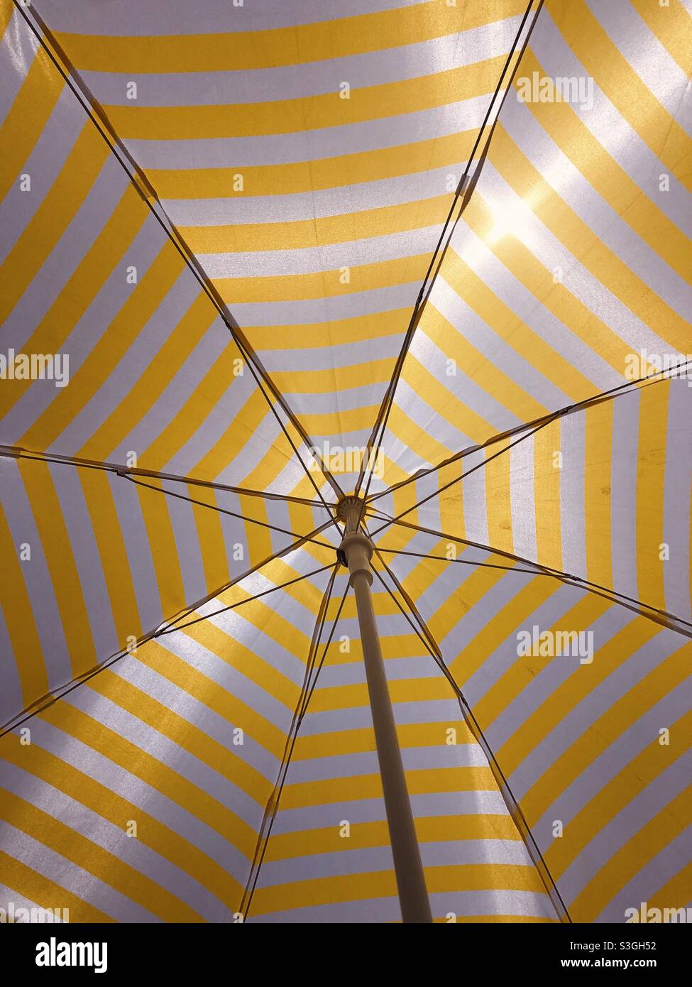Yellow and white striped beach umbrella Stock Photo Alamy