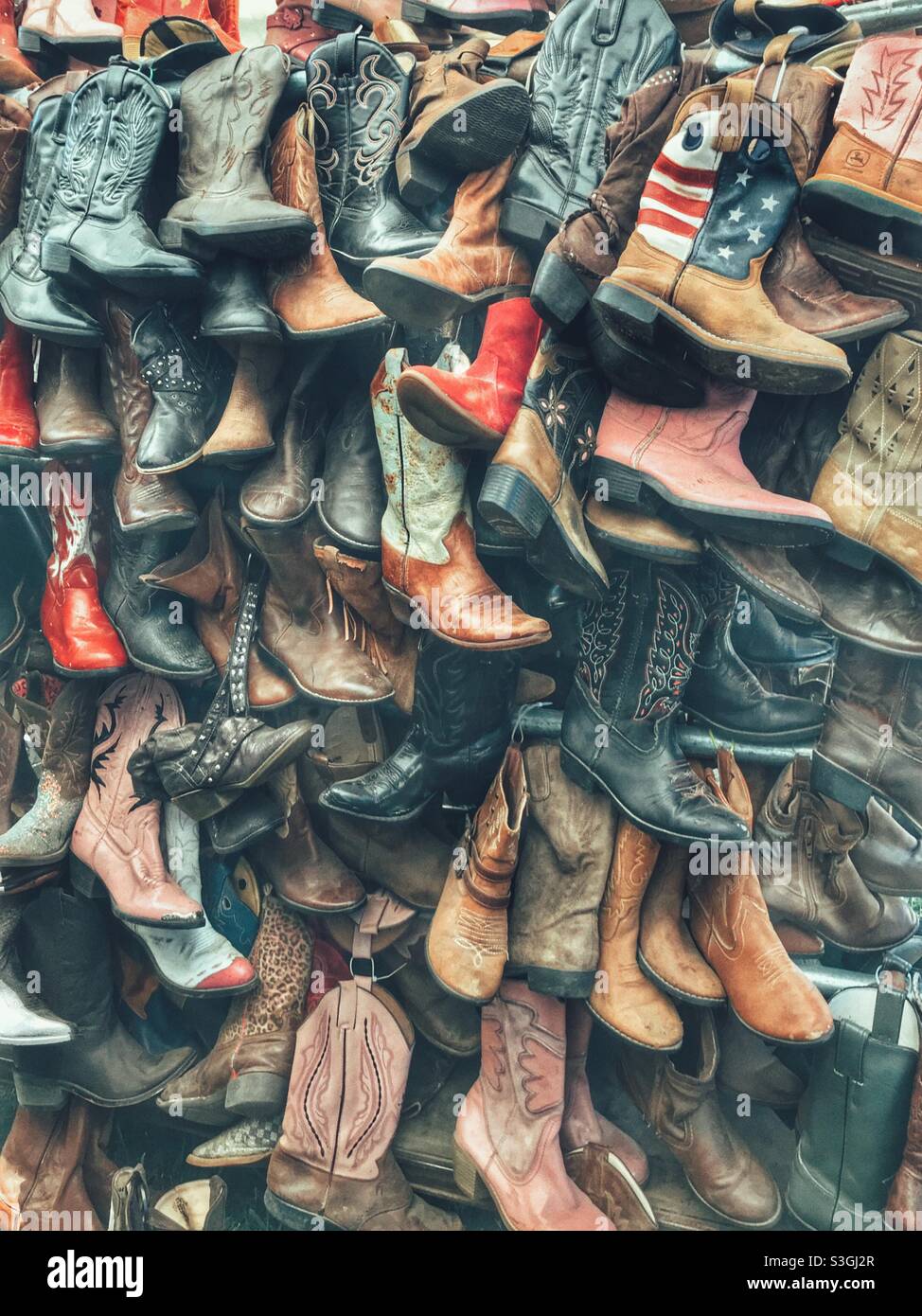 Vender’s display of used boots for sale Stock Photo