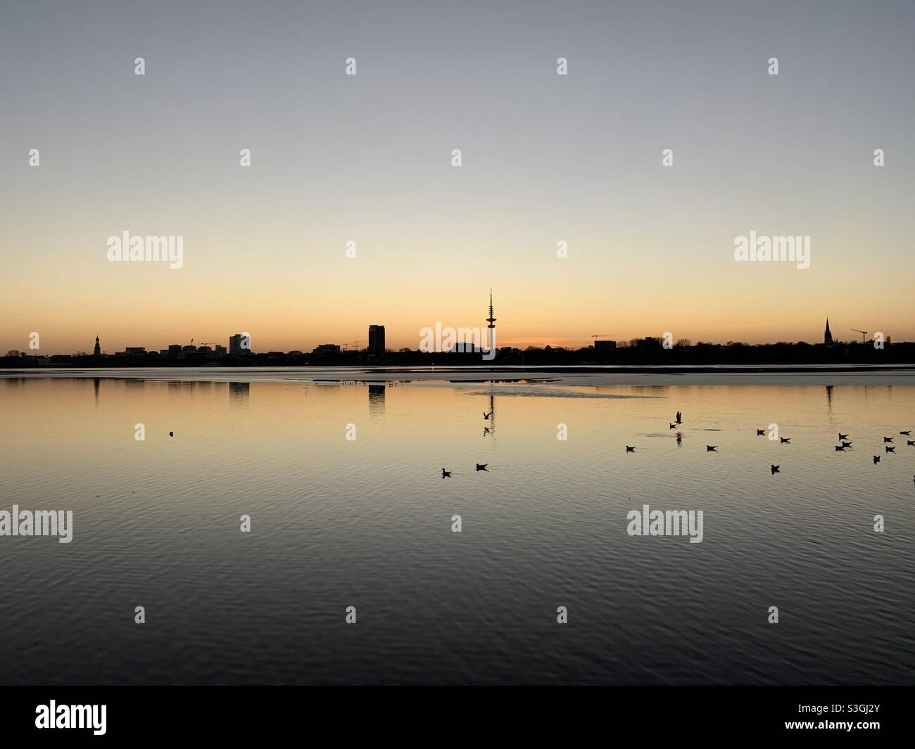View of the Hamburg skyline from the Alster lake during sunset on an early spring day Stock Photo