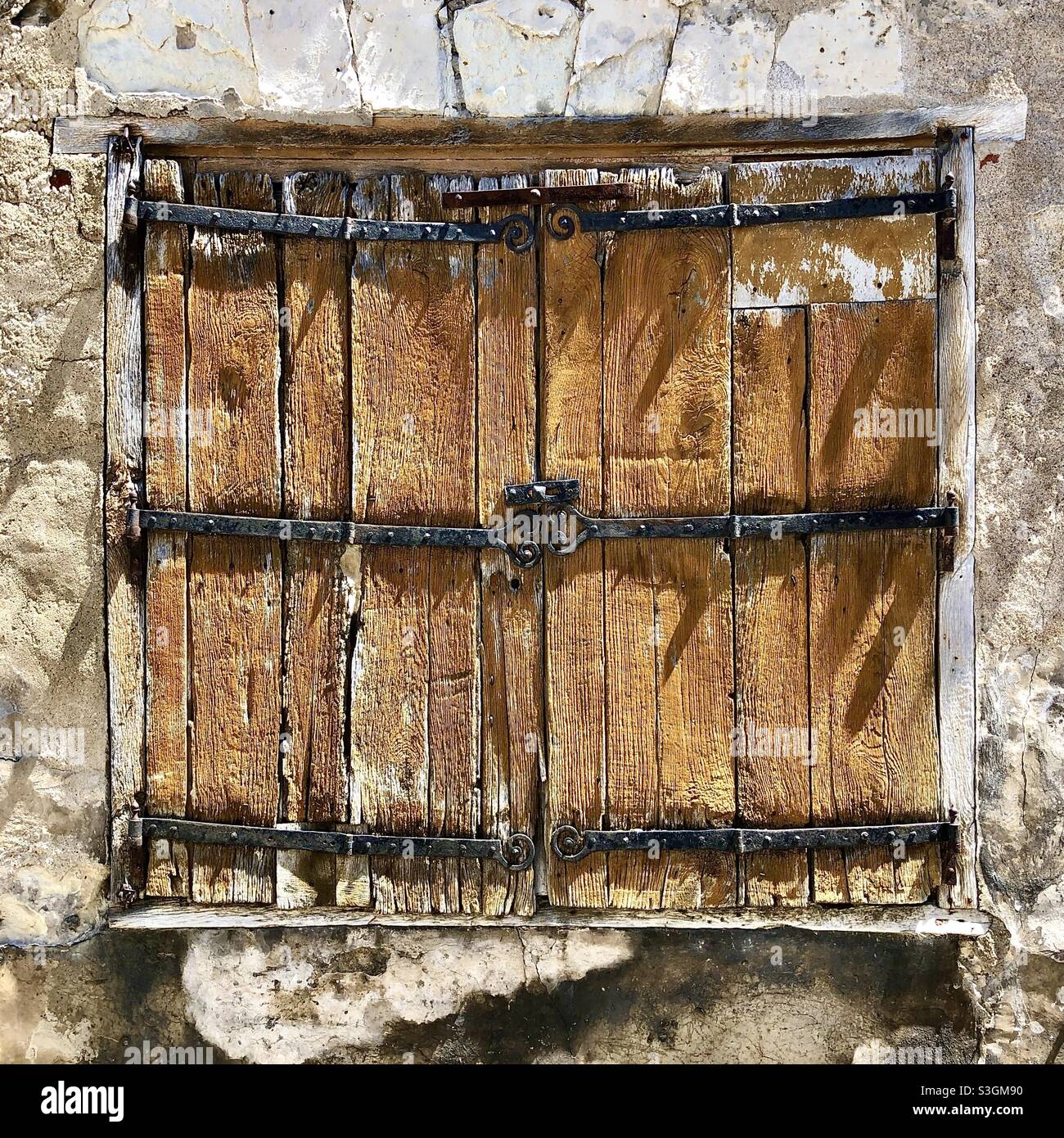 Old oak window shutters with hand-made iron hinges - France. Stock Photo