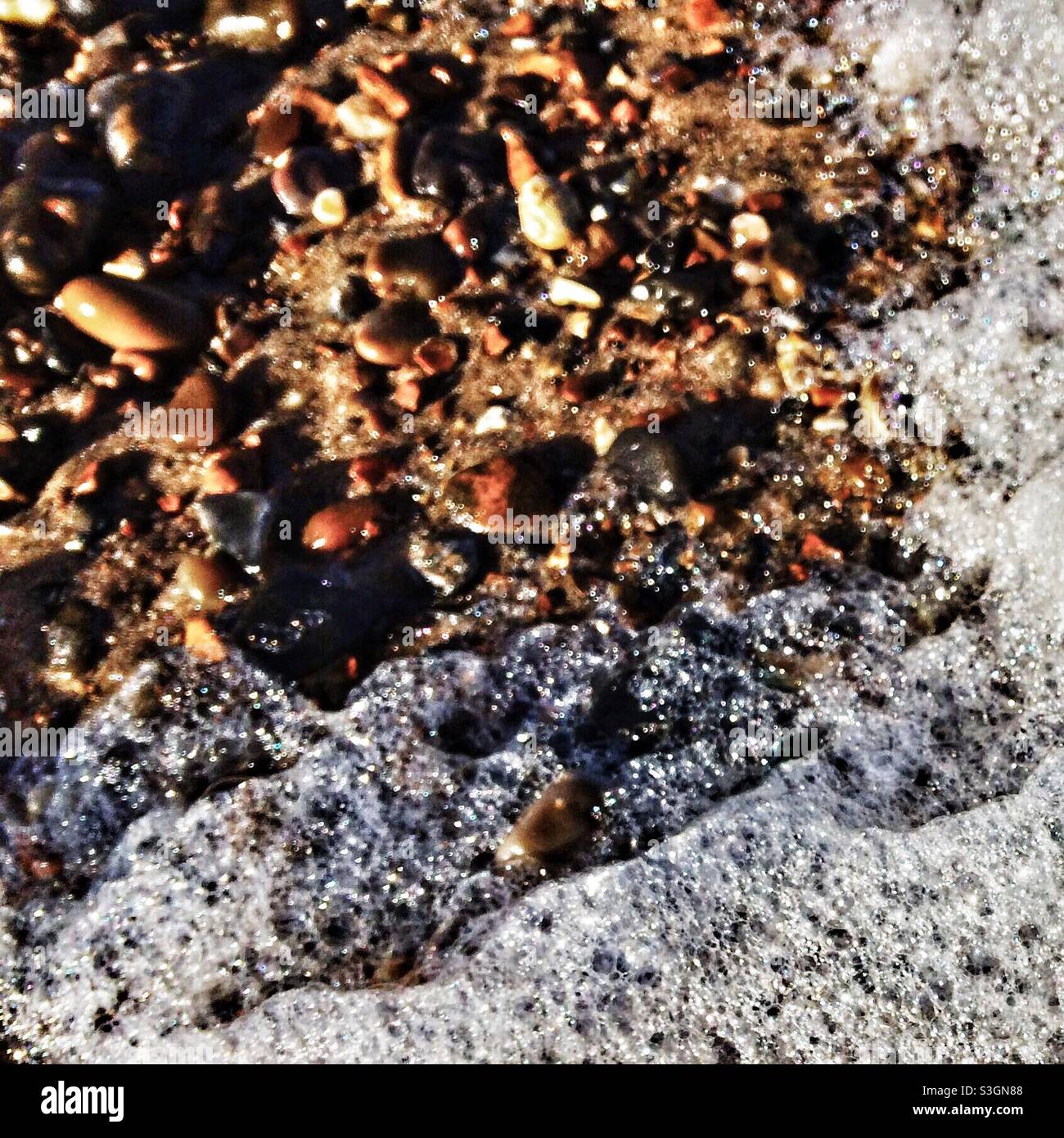 Sea foam and pebbles Stock Photo