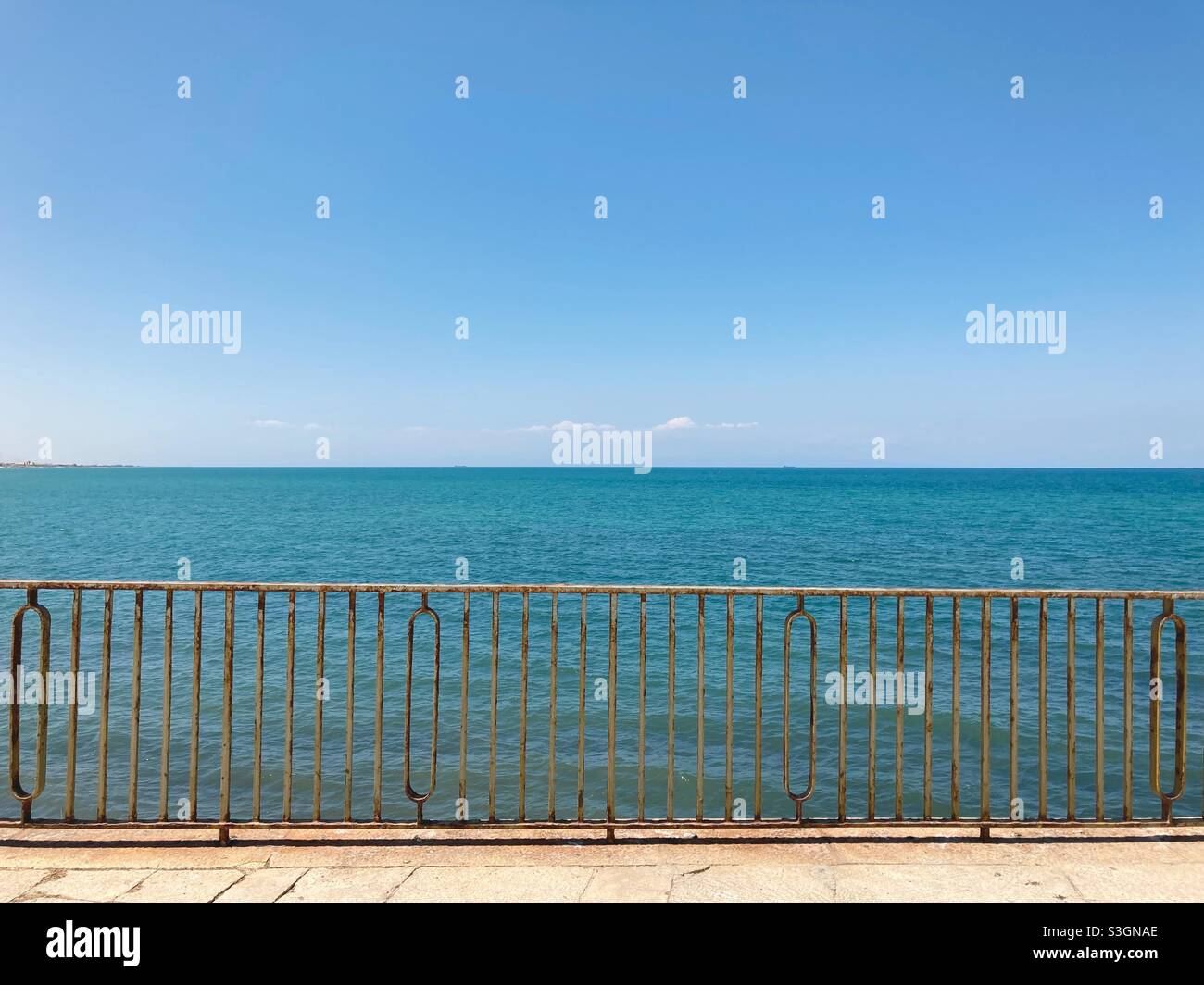 A metal fence at the Adriatic sea in the town of Trani, Italy - Smartphone Captured Stock Image