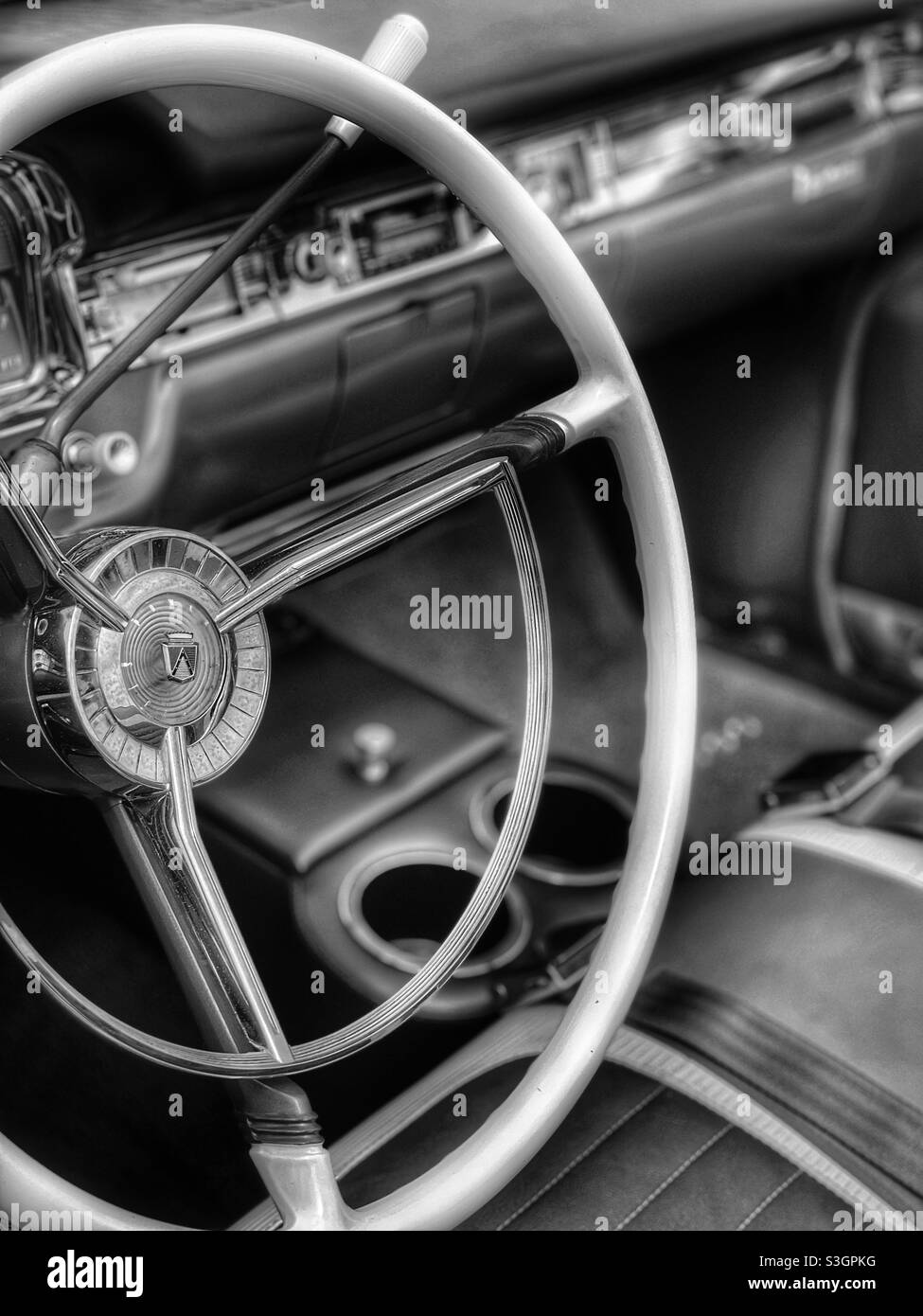 Black and white image of a vintage automobile dashboard and steering wheel Stock Photo