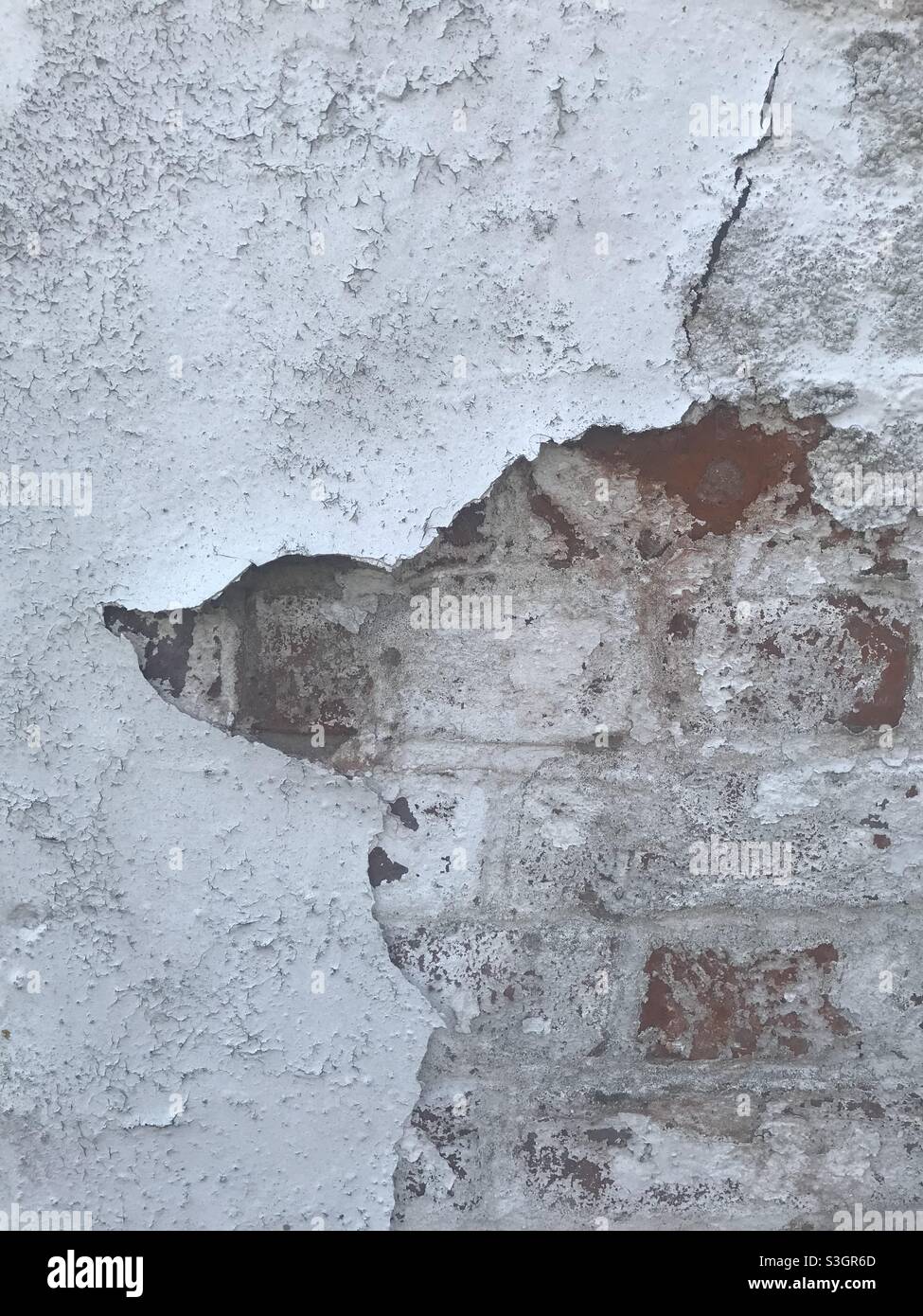 Exposed brick wall peeling white paint Stock Photo