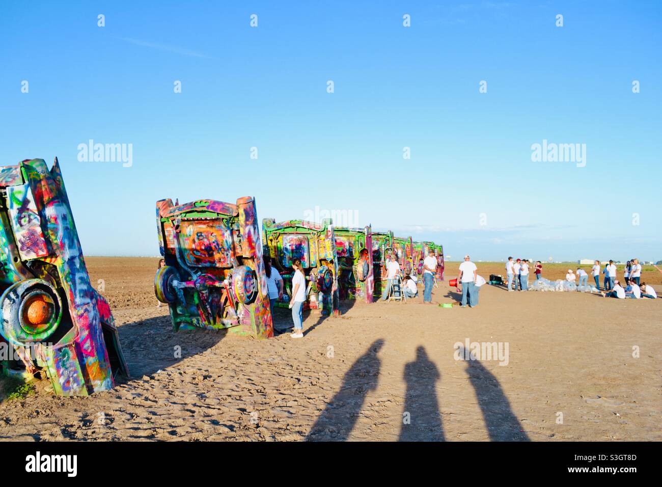 School students spray painting cars at Cadillac ranch, USA Stock Photo