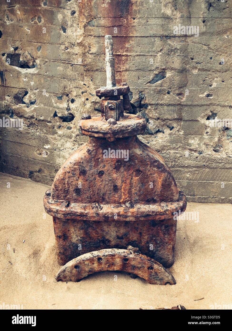 The mechanism to drain a tidal pool which is now half buried under the sea sand - Smartphone Captured Stock Image