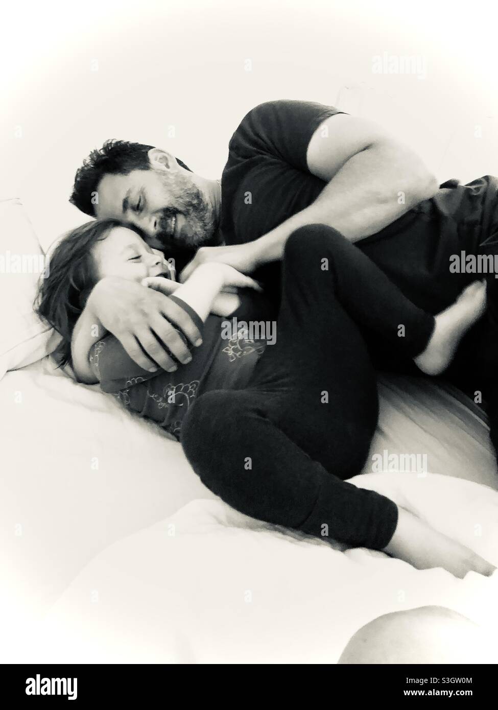 Father playing and hugging his 3 1/2 year-old son. - Smartphone Captured Stock Image