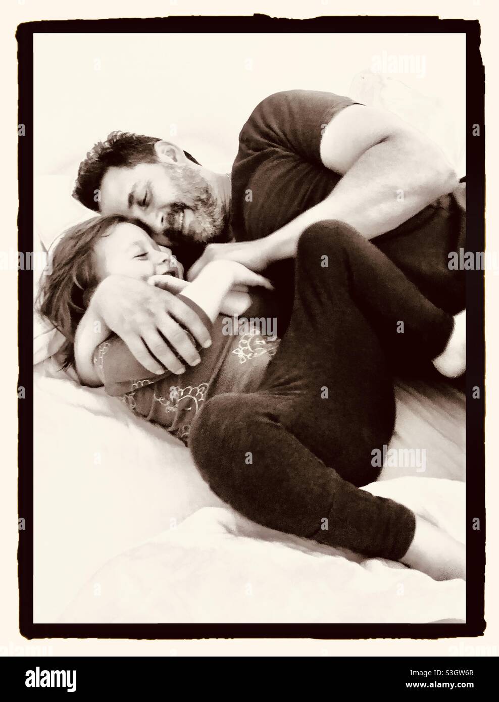 Father with his toddler son, cuddling and laughing together. - Smartphone Captured Stock Image