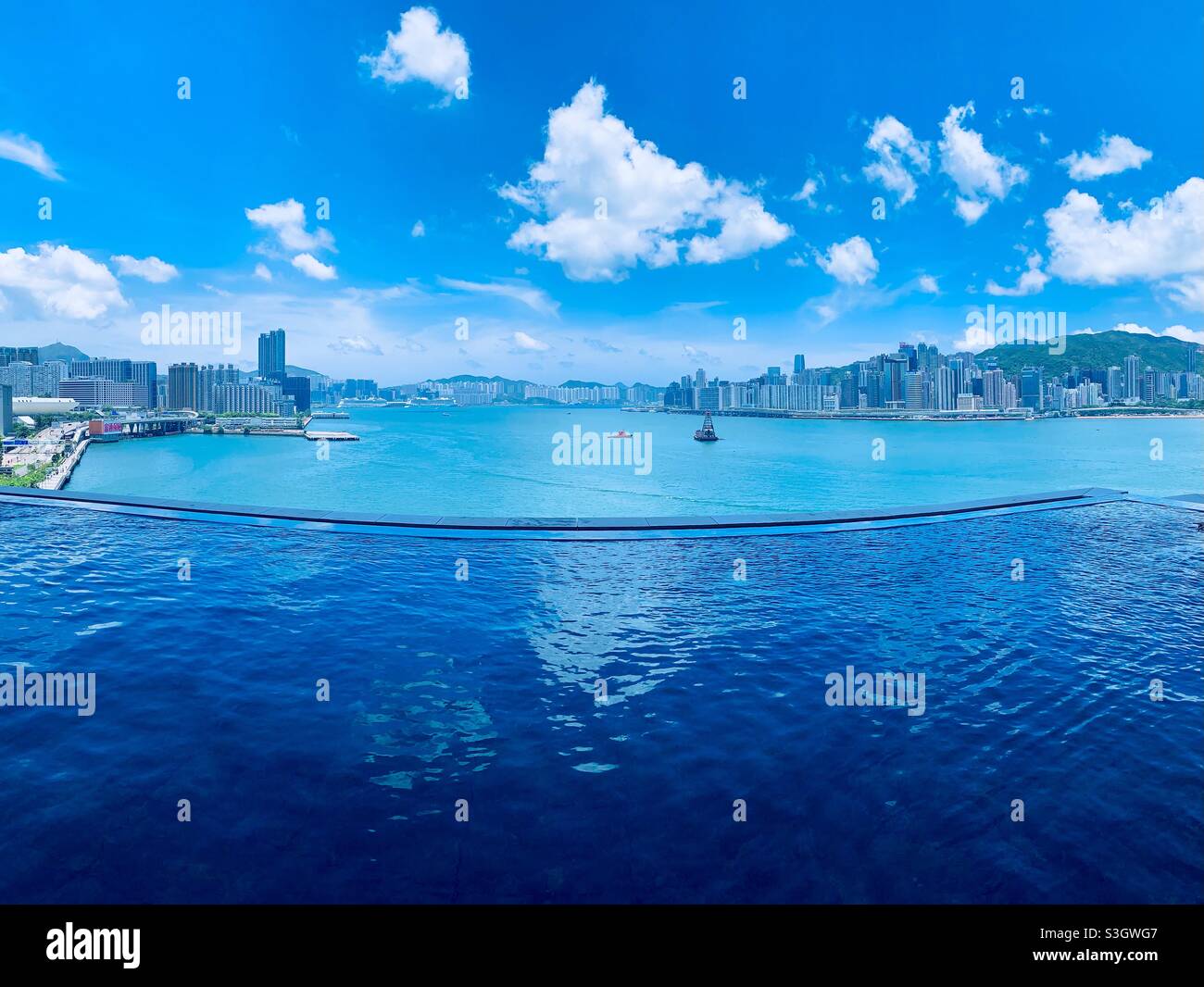 View of Victoria harbour and HK island seen from the infinity pool of the Rosewood hotel in Hong Kong. - Smartphone Captured Stock Image