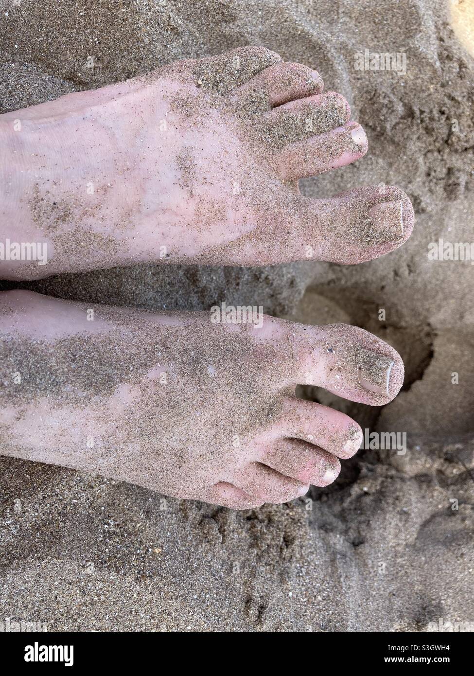 Feet in the sand, Minehead beach, summer 2021 - sand between the toes Stock Photo