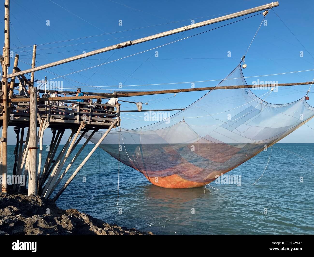 A demonstration of fishing with a Traditional Trabucco on the Coast near the Apulian town Vieste, Gargano, Puglia, Italy - Smartphone Captured Stock Image