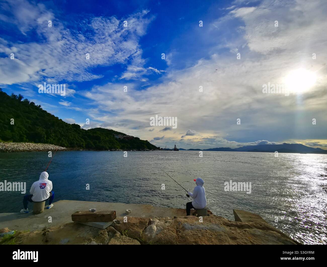 Fishing from a pier in Pak Kok, Lamma island, Hong Kong. - Smartphone Captured Stock Image