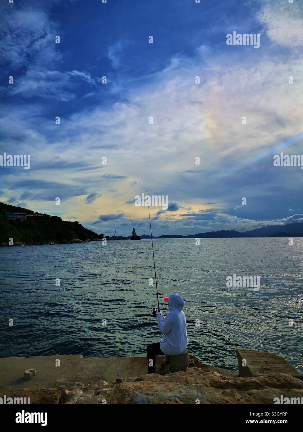 Fishing from a pier in Pak Kok, Lamma island, Hong Kong. - Smartphone Captured Stock Image