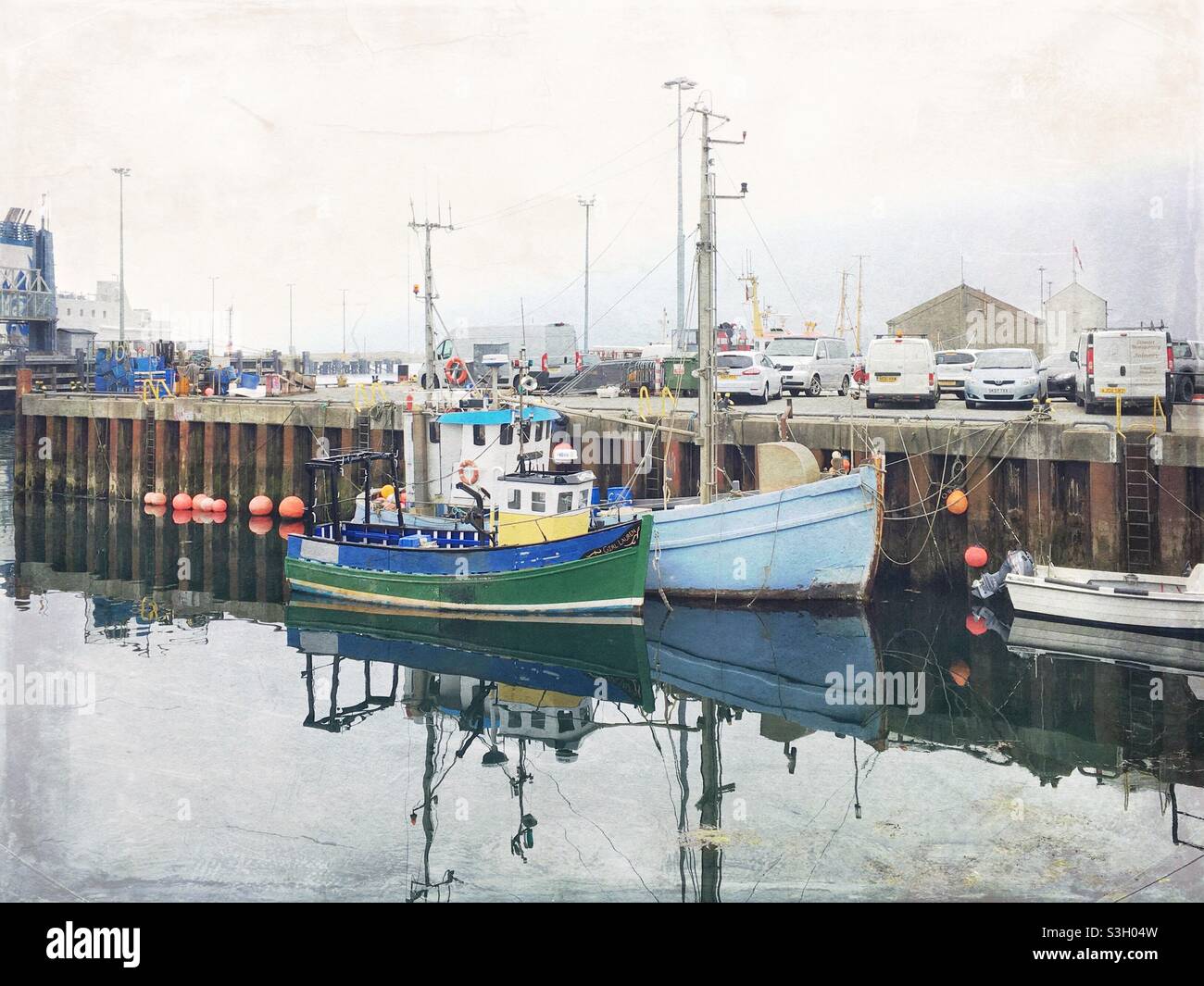 Small fishing boats in Stromness Harbour on an overcast day, image processed to have a grungy, nostalgic feeling Stock Photo