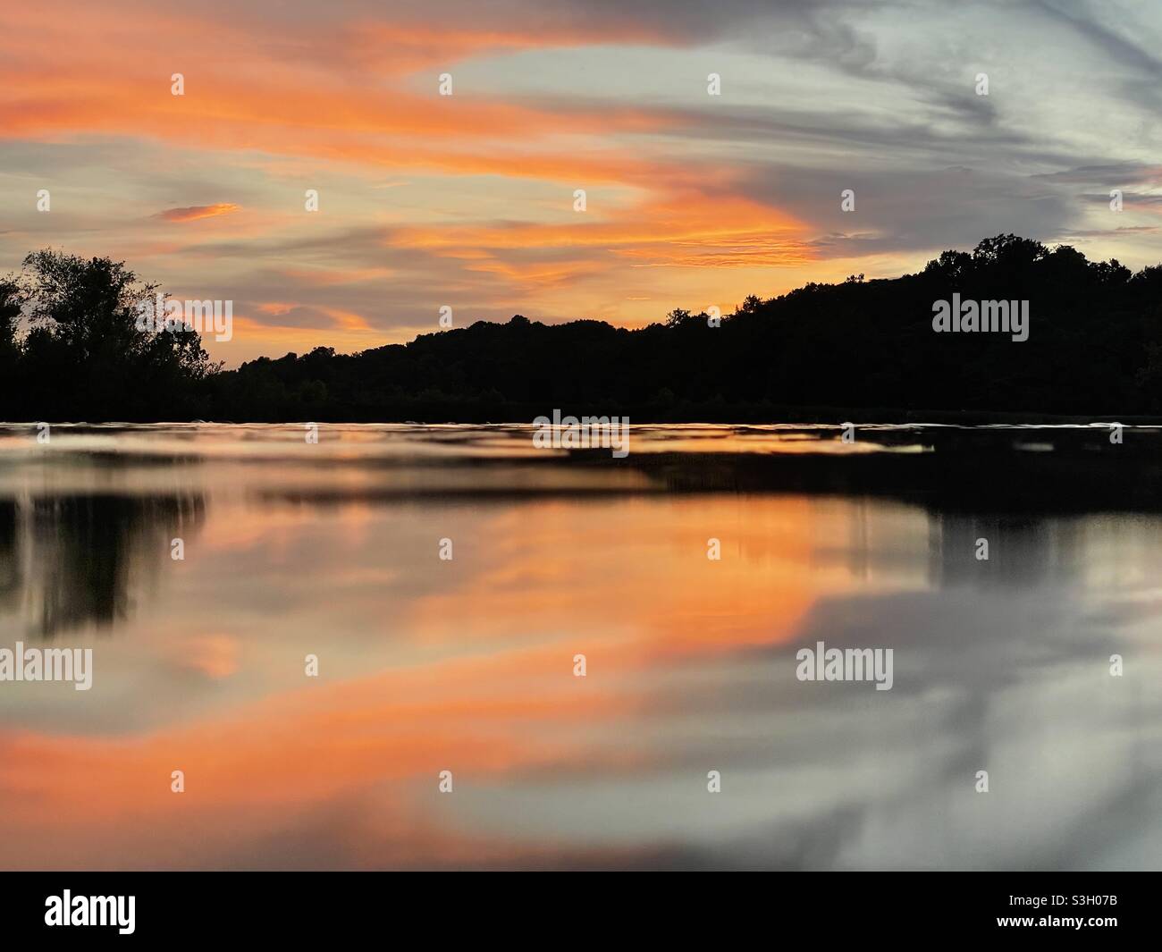 A bright orange sunset reflected over the James River in Richmond, VA. Stock Photo