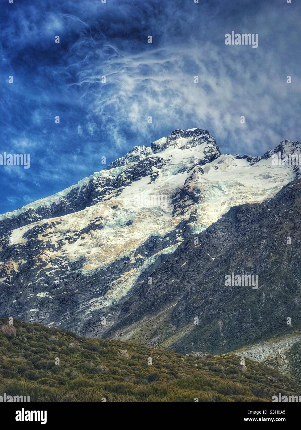 Spectacular clouds over a snowy mountain peak as seen from the Hooker Valley Track in the Aoraki Mount Cook National Park in the Canterbury region, South Island, New Zealand - Smartphone Captured Stock Image