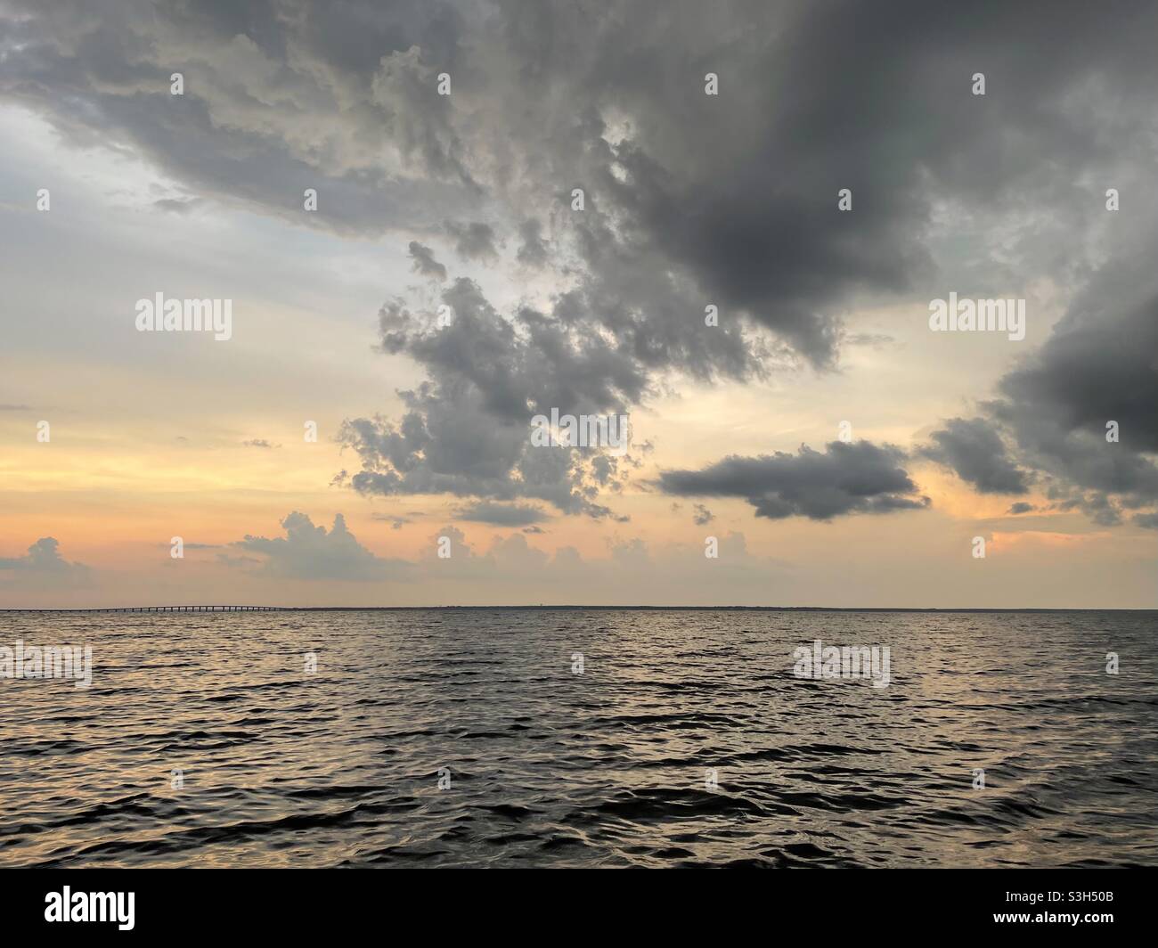 Stormy sunset skies over bay water Stock Photo - Alamy