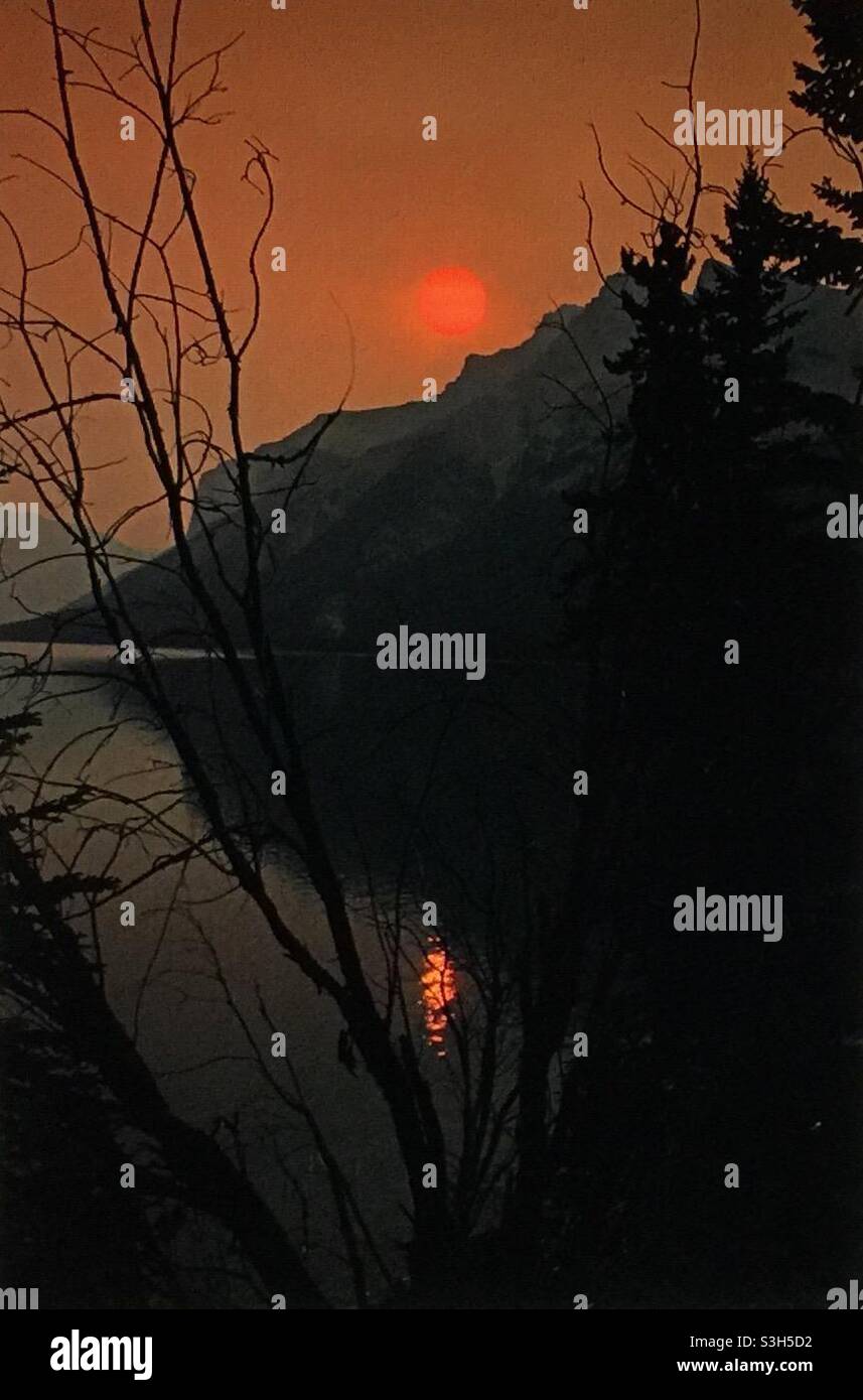 Smoky sunrise, Lake Minniwanka, Banff National Park, forest fires, global warming, mountains, Rockies, - Smartphone Captured Stock Image