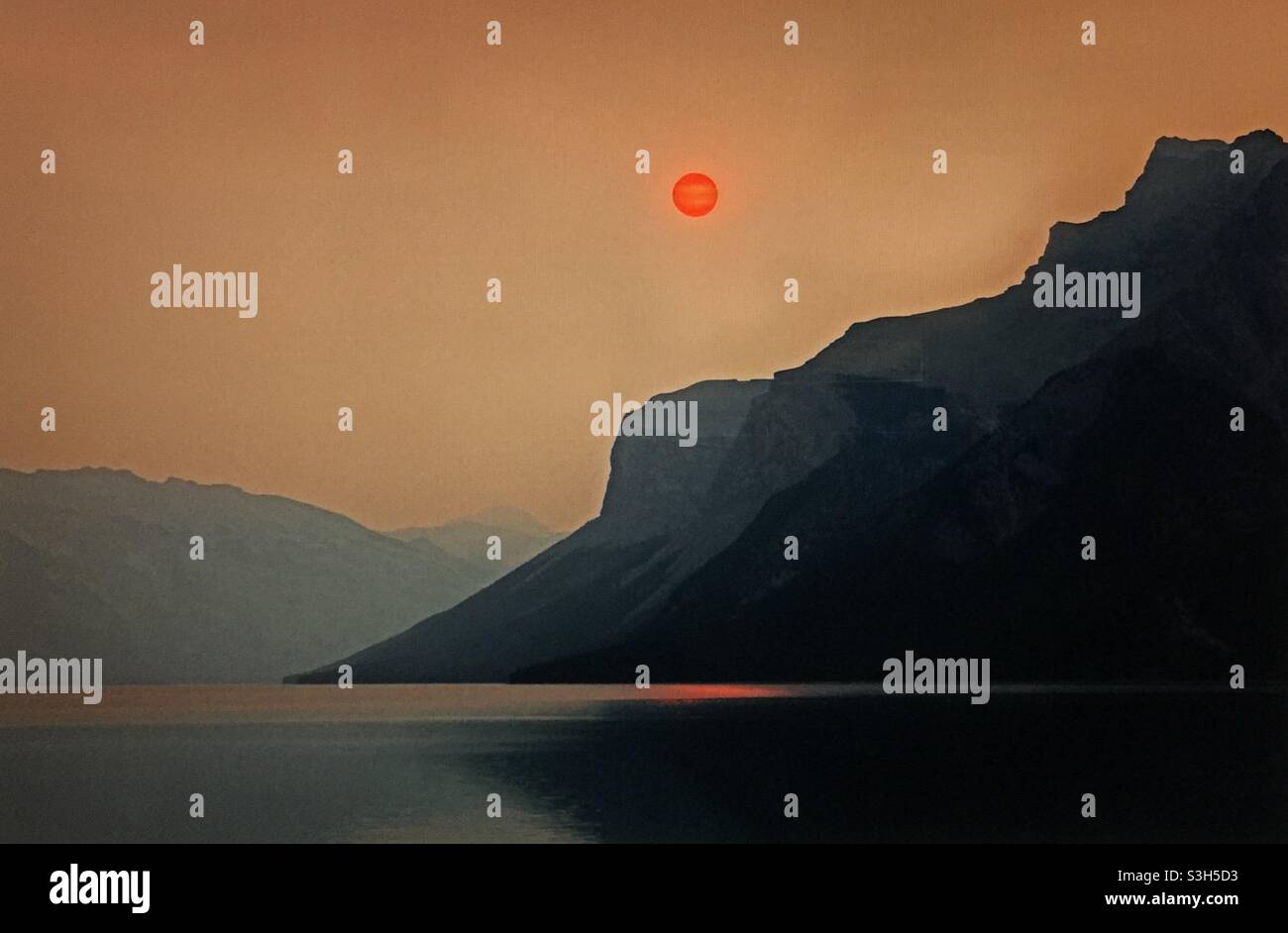 Smoky sunrise, Lake Minniwanka, Banff National Park, forest fires, global warming, mountains, Rockies, - Smartphone Captured Stock Image