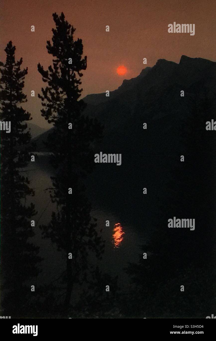 Smoky sunrise, Lake Minniwanka, Banff National Park, forest fires, global warming, mountains, Rockies, - Smartphone Captured Stock Image