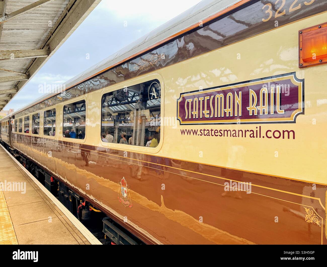 Polished vintage Pullman carriage of a luxury train alongside a platform at its destination Stock Photo