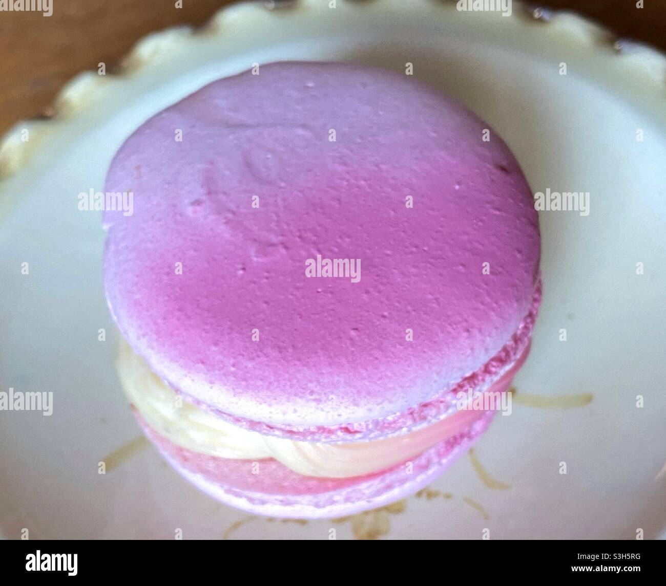 Macaron in pink colour on a vintage saucer Stock Photo